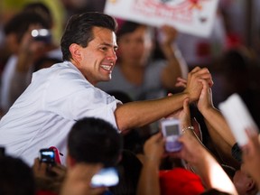 Mexican presidential candidate for the Institutional Revolutionary Party, Enrique Pena Nieto, greets supporters during a rally in Nezahualcoyotl, Mexico State, Mexico on April 28, 2012. (Alfredo Estrella/AFP)