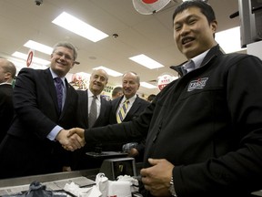 Prime Minister Stephen Harper, with cabinet ministers Julian Fantino and Rob Nicholson pay a visit in Toronto to David Chen at the Lucky Moose Food Mart in February 2011. (Toronto Sun files)