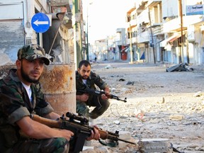Free Syrian Army fighters patrol a street in Qusair town near Homs city, northern Syria May 5, 2012. (REUTERS)