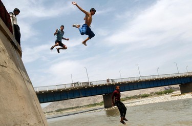 Boys jump into a river to cool themselves in Jalalabad province on May 6, 2012. (REUTERS/Parwiz)