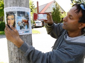 Ron Banerjee from the Canadian Hindu Advocacy tapes up posters Friday around the Scarborough neighbourhood where Omar Khadr’s grandfather lives. It is believed Khadr may return to the neighbourhood. (Craig Robertson/Toronto Sun)