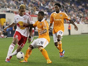 Corey Ashe and Alex Dixon, of the Houston Dynamo, defend against Juan Agudelo, of the New York Red Bulls, at Red Bull Arena on May 9, 2012. (GETTY)