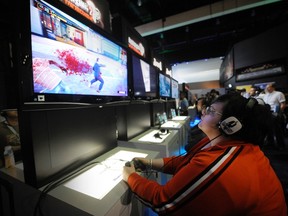 Attendees play games in the Capcom booth at E3, the Electronic Entertainment Expo, in Los Angeles June 8, 2011. REUTERS/Phil McCarten
