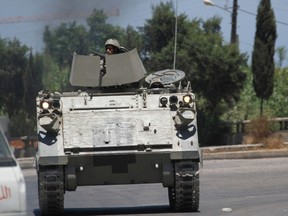 Lebanese army soldiers patrol near the Sunni Muslim Bab al-Tebbaneh neighbourhood in Tripoli, northern Lebanon, as smoke from clashes rises in the background June 2, 2012. (REUTERS/Omar Ibrahim)