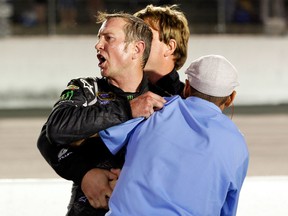 Kurt Busch is held back during scuffle with Ryan Newman during the NASCAR Sprint Cup Series Bojangles' Southern 500 at Darlington Raceway on May 12, 2012 in Darlington, South Carolina. (Geoff Burke/Getty Images for NASCAR/AFP)