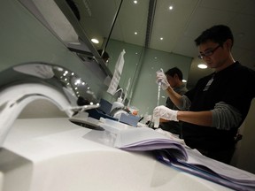 Workers check the water quality inside a toilet closed for disinfection after bacteria was found to have spread throughout the building. (REUTERS FILE PHOTO/Bobby Yip)