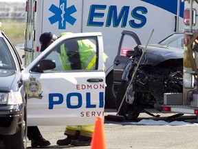 Firefighters, police and EMS technicians responded to a three-car collision at Manning Drive and 153 Avenue in Edmonton, Alberta, on May 13, 2012. A dog was comforted by an Edmonton Police Service officer while emergency responders cleaned up the wrecks. IAN KUCERAK/EDMONTON SUN/QMI AGENCY