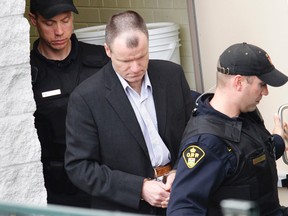 Convicted killer Russell Williams is escorted out of court by OPP officers in October 2010. - FILE PHOTO BY JEROME LESSARD/The Intelligencer/QMI Agency