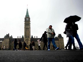 People leave Centre Block on Parliament Hill after a brief rain storm hit the city of Ottawa, June 12, 2012. (Chris Roussakis/QMI Agency)