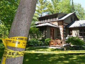 Police tape surrounds a log home at 133 Kitzbuhl Crescent in Craigleith on Thursday June  07, 2012. The bodies of a man and a woman were found inside by O.P.P. on Wednesday. This is a photograph of the back of the home.--JAMES MASTERS /The Sun Times/QMI Agency
