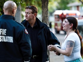 A distraught woman looks on at a house fire near 112 Avenue and 92 Street Wednesday night. (CODIE MCLACHLAN/Edmonton Sun)