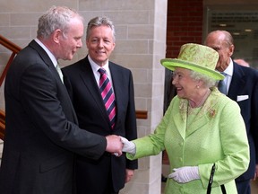 Britain's Queen Elizabeth II (2nd R) shakes hands with Northern Ireland Deputy First Minister Martin McGuinness (L) watched by First Minister Peter Robinson (2nd L) at the Lyric Theatre in Belfast, Northern Ireland, on June 27, 2012. Queen Elizabeth II shook hands with former IRA commander Martin McGuinness on Wednesday in a landmark moment in the Northern Ireland peace process, Buckingham Palace said. The initial handshake between the queen and McGuinness, who is now deputy first minister of the British province, took place away from the media spotlight behind closed doors in Belfast's Lyric theatre.  AFP PHOTO / PAUL FAITH/POOL