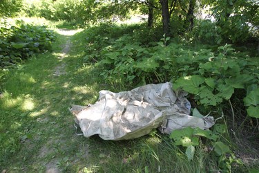 Police continue to investigate the area close to where suspected serial killer Shawn Lamb lived until his arrest.  This is a large nylon bag close to a train bridge along the riverbank in the area where Tanya Nepinak's family believe here remains may be located.   Friday, June 29, 2012.  (Chris Procaylo/Winnipeg Sun)