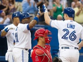 Toronto Blue Jays Adam Lind (R) is congratulated by team mate Rajai Davis after he hit a three run home run in the fourth inning of their American League MLB baseball game against the Los Angeles Angels in Toronto June 29, 2012. (REUTERS/Fred Thornhill)