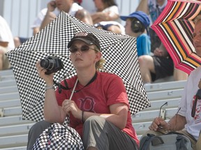 Under the checkered umbrella was the best place to be in the main grandstand as the temperatures hit 39C or 102F with the humidity Friday at the Honda Indy Toronto. (Jack Boland / Toronto Sun /