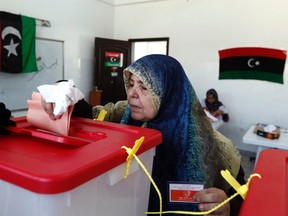 A woman voter drops voting papers inside a ballot box in Sirte July 7, 2012. (Reuters/ANIS MILI)