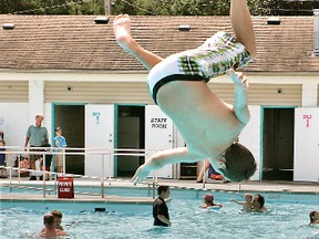 11-year-old Andrew Hazell does a flip as he jumps into the Paris Community Pool in Lions Park at its official opening day Saturday. - CHRISTOPHER SMITH, The Expositor
