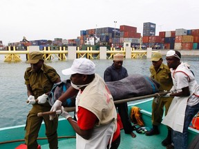 Rescuers carry the recovered body of a passenger killed during the ferry tragedy from a boat at the Port of Zanzibar, July 19, 2012. (Reuters/THOMAS MUKOYA)
