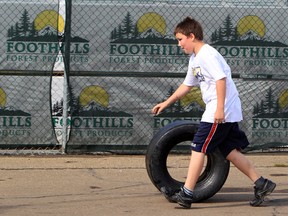 Joshua Hamelin, 11,  rolls his souvenir tire at the Edmonton Indy, Saturday July 21, 2012. DAVID BLOOM EDMONTON SUN  QMI AGENCY