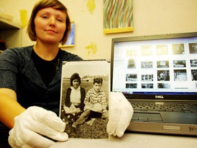 Krista McCracken, an archives technician at the Shingwauk Residential Schools Centre at Algoma University, holds up one of the centre's archived photos, in Sault Ste. Marie, Ont. on Thursday, July 19, 2012. More than 24,000 photos and hundreds of thousands of pages of text from Indian residential schools are now available online through the Shingwauk Residental Schools Centre website.  MICHAEL PURVIS/SAULT STAR/QMI AGENCY