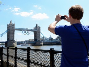 A tourist snaps pictures in front of the Tower Bridge ahead of the 2012 Olympic Games on July 22, 2012 in London, England. (Jamie Squire/Getty Images/AFP)