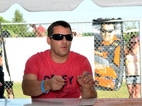 Tony Stewart , 2011 Nascar Sprint Cup Champion, reaches for the next item to sign at the Meet & Greet at Ohsweken Speedway, Ohsweken, Ontario, on Monday, July 30, 2012. Prior to the race 150 fans paid $50 for a one-hour gathering where Stewart signed pictures, shirts, hats and "skin."