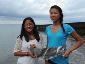 Sarnia Riding Club members Lisa Cooper, 12, and her sister Amy, 13, hold a piece of metal from a U.S. Second World War P-47 Thunderbolt plane they found in Lake Huron a few feet from shore Sunday. (BARBARA SIMPSON /QMI AGENCY)