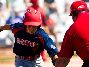 Hasting, B.C.’s Thomas Neal celebrates a run with coach Vito Bordignon during Little League Canadian Championship at John Fry Park on Monday. CODIE MCLACHLAN/EDMONTON SUN