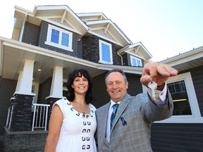 Alberta Cancer Foundation CEO and cancer survivor Robert Bainbridge pose for a photo outside the Cash and Cars For Cancer lottery grand prize home at 1728 Adamson Cresent SW, Wednesday Aug. 8, 2012. DAVID BLOOM EDMONTON SUN  QMI AGENCY