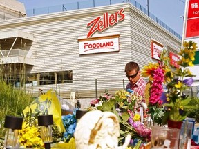 Flowers and mourners are seen at the site of the collapsed mall.