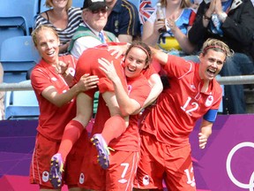 Canada's Brittany Timko, Rhian Wilkinson and Christine Sinclair celebrate with teammate Diana Matheson after Matheson scored the winning goal to beat France 1-0 and win the soccer bronze at the 2012 Olympic Games Thursday. (AL CHAREST/QMI AGENCY)