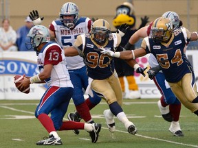 Bombers’ defenders Brandon Collier (centre) and Kenny Mainor (right) chase Alouettes QB Anthony Calvillo during last Friday’s 36-26 Montreal win. The Bombers defence is giving up a CFL-worst 333 yards per game and are a shadow of their former Swaggerville selves. (FRED GREENSLADE/Reuters files)