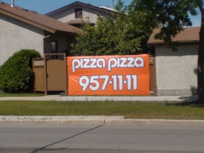 A banner fastened to a residential fence on Southglen Boulevard at Ashworth Street in south St. Vital, advertising Pizza Pizza, on Thursday. The City of Winnipeg said it appeared to violate a zoning bylaw. The sign had been removed and placed in the homeowner's backyard by Saturday. (Ross Romaniuk/Winnipeg Sun)