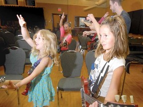 KEEP ON ROCKING
SCOTT WISHART The Beacon Herald
Josie Hallatt, left, 9, and Ashley Humphrey, 10, work on their best rock-guitar flourish during the 'School of Rawk' summer day camp of Stratford Summer Music on Tuesday. Two dozen youngsters aged 8-17 are taking part in beginner and intermediate camps, getting rock tips from members of the band Speed Control.