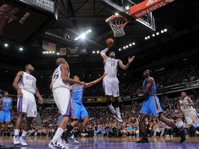 DeMarcus Cousins, of the Sacramento Kings dunks over Thabo Sefolosha, and Kendrick Perkins (5) of the Oklahoma City Thunder on April 20, 2012 at Power Balance Pavilion in Sacramento, California. (AFP)