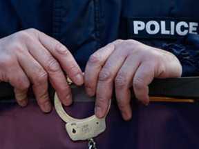 A policeman holds a pair of handcuffs. (John Kolesidis/REUTER...