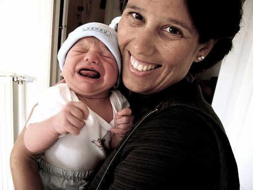 Smiling parent, crying baby
