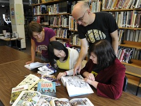 VANCOUVER, B.C.: AUGUST 16, 2011 -- English teacher Guy Demers looks on as students Tegan Samija (L), Vivian Ta (C) and Meghan Corless (R) read graphic novels in the library at Sir Charles Tupper Secondary on Friday, September 16, 2011. Graphic novels are being used to help promote reading among kids who don't normally read. (photo by Jenelle Schneider/PNG)