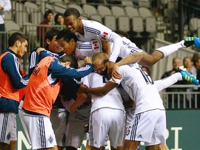 Vancouver Whitecaps players pile on teammate Long Tan after his goal against D.C. United during their MLS game at BC Place Stadium on Wednesday, Oct. 12, 2011 in Vancouver. The Whitecaps won 2-1. (Photo by Jeff Vinnick, Getty Images)