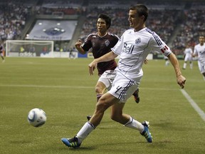 Alain Rochat of the Vancouver Whitecaps moves the ball upfield as he’s pursued by Kosuke Kimura of the Colorado Rapids during their Major League Soccer game at BC Place Stadium on Saturday. (Photo by Jeff Vinnick, Getty Images)