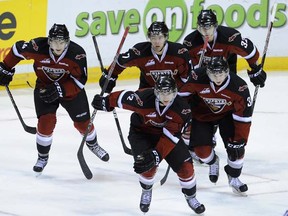 Giants left winger Cain Franson leads teammates back to bench for high fives after scoring opening goal against Oil Kings on Wednesday. (photo by Mark van Manen, PNG)