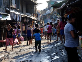 Philippine residents walks the street in one of the shanty towns in Manila on April 8, 2011. At night, these children sleep in the street under a sheet of canvas. But at least they're warm, unlike the children of the Attawapiskat First Nation.  AFP PHOTO / JAY DIRECTO