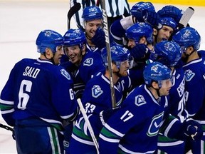 Vancouver Canucks' Sami Salo, far left, of Finland, celebrates with his teammates after scoring the game-winning goal against the Minnesota Wild during overtime of an NHL hockey game  in Vancouver, British Columbia, Canada  on Saturday Oct. 22, 2011.  Vancouver won 3-2.   (AP Photo/The Canadian Press, Darryl Dyck)