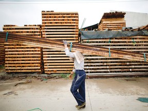 Labourers move bundles of wooden beams at a timber trading yard in Anqing, Anhui Province, China in July 2011. Lumber sales to China have been growing. Qilai Shen/Bloomberg