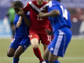 Haiti's Wisline Dolce, left, and Samantha Marie-Ann Brand, right, try to stop Canada's Christine Sinclair during the second half of CONCACAF Women's Olympic qualifying soccer in Vancouver, British Columbia, Thursday, Jan. 19, 2012. (AP Photo/The Canadian Press, Jonathan Hayward)