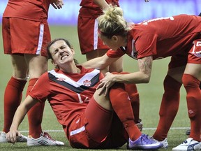 Canada’s star Christine Sinclair winces in pain on the field as teammate Kelly Parker comforts her after being on the receiving end of a hard tackle against Mexico in the CONCACAF women’s Olympic soccer qualifying semifinal on Jan. 27, 2012  at BC Place Stadium. Sinclair recovered to finish the game and scored twice as Canada won 3-1 to secure a berth at the London Summer Games. (Photo by Ian Lindsay, PNG)