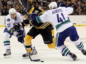 BOSTON, MA - JANUARY 07:  Dale Weise #32 of the Vancouver Canucks steals the puck from Tyler Seguin #19 of the Boston Bruins as Andrew Alberts #41 of the Canucks defends on January 7, 2012 at TD Garden in Boston, Massachusetts. The Vancouver Canucks defeated the Boston Bruins 4-3.  (Photo by Elsa/Getty Images)