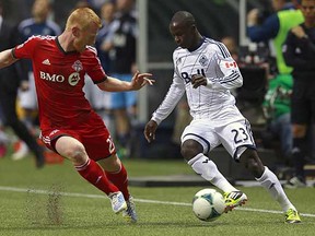 Vancouver Whitecap Kekuta Manneh (right) makes life difficult for then-Toronto FC defender Richard Eckersley during a March 2013 MLS game at BC Place Stadium.