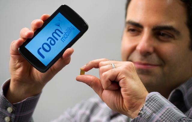 Emir Aboulhosn founder and CEO of roam Mobility holds a cell phone and a sim card. 