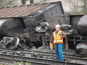 A Canadian National Railway official stands on the tracks after seven Canadian Pacific Railway train cars derailed on the CN Rail tracks spilling coal from three of the cars in Burnaby on January 11, 2014.